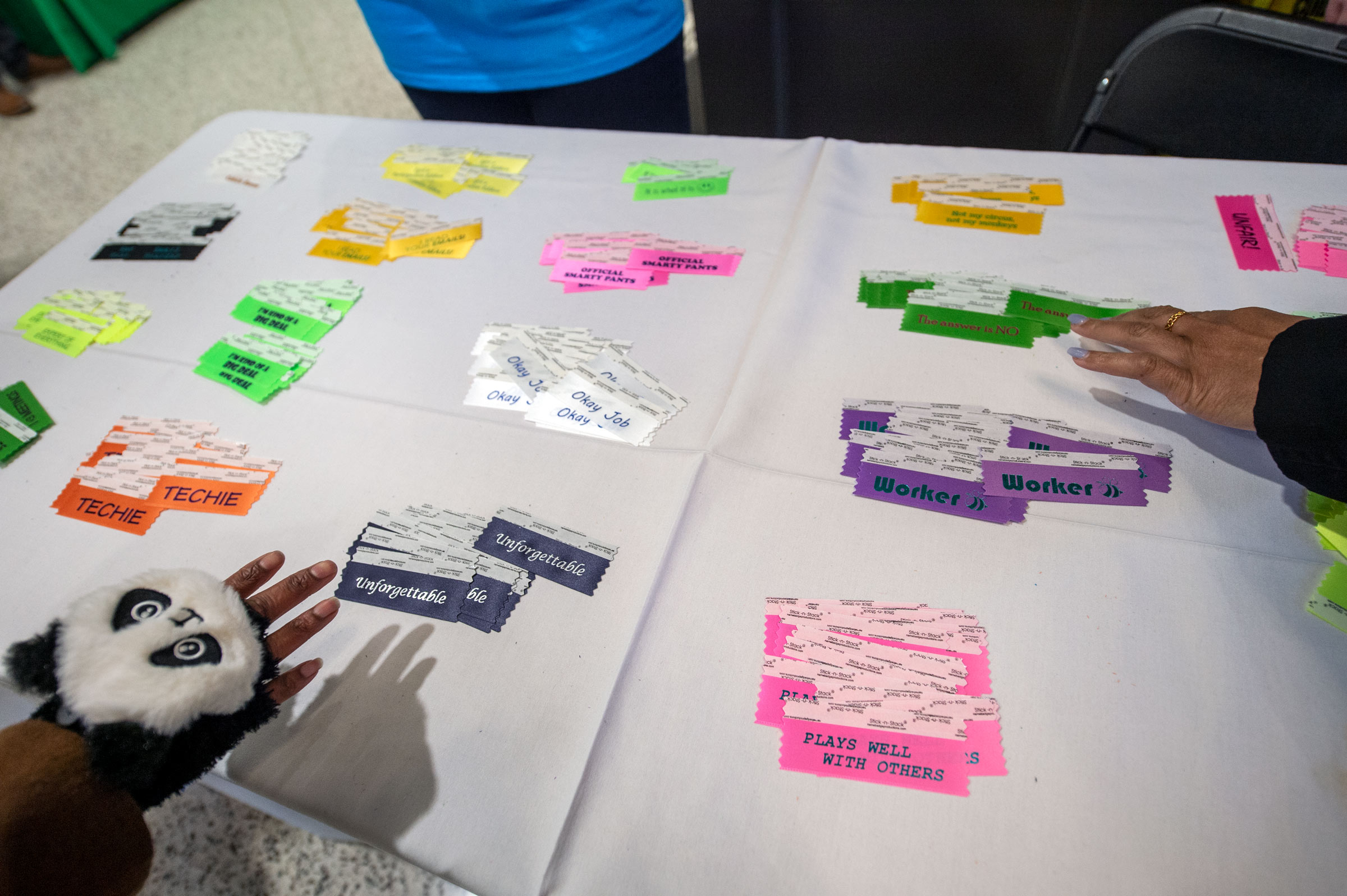 Employees hands reach for "fun" ribbons to add to their conference nametags.