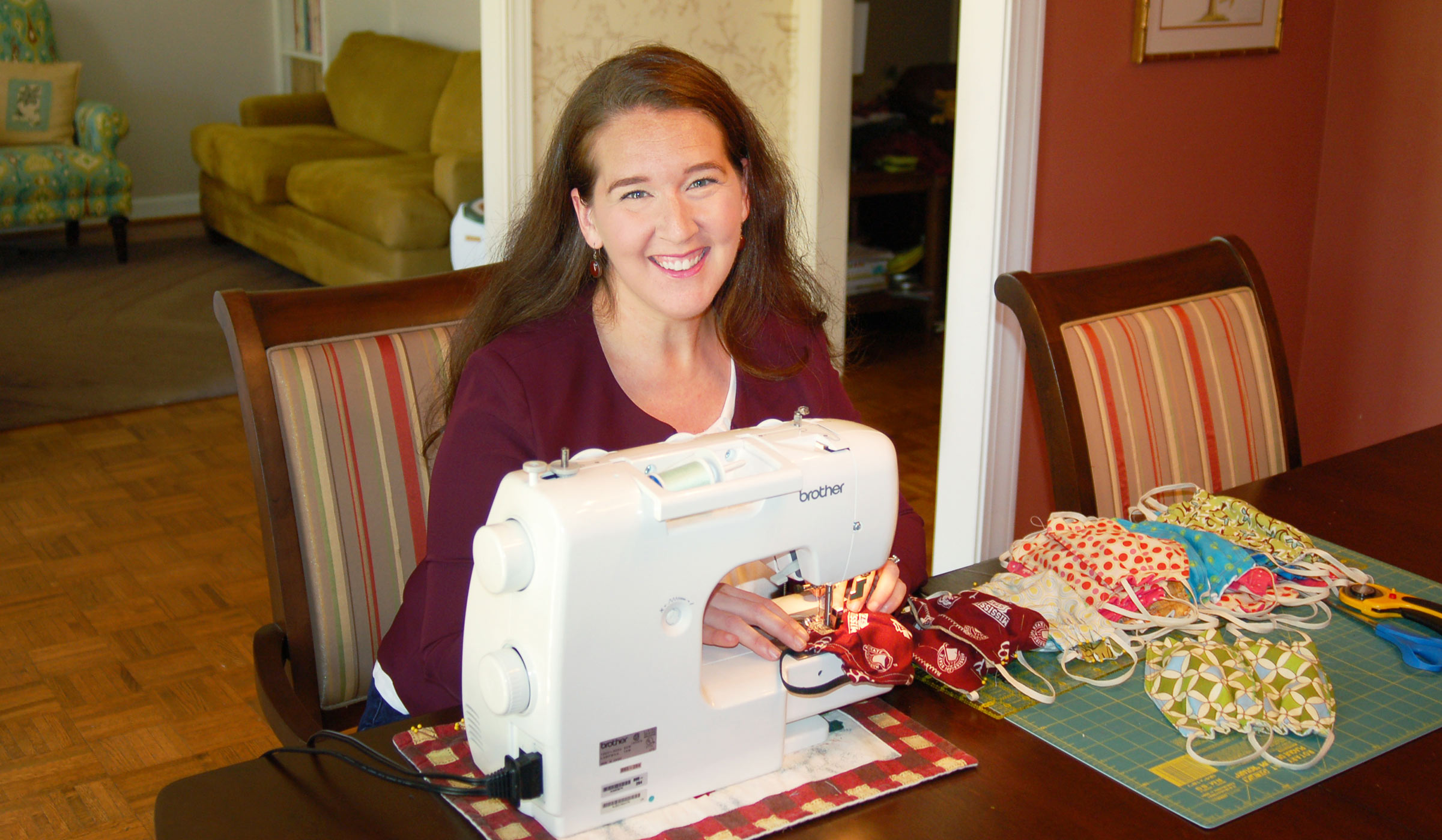 Emily Marett, pictured sewing masks in her home.