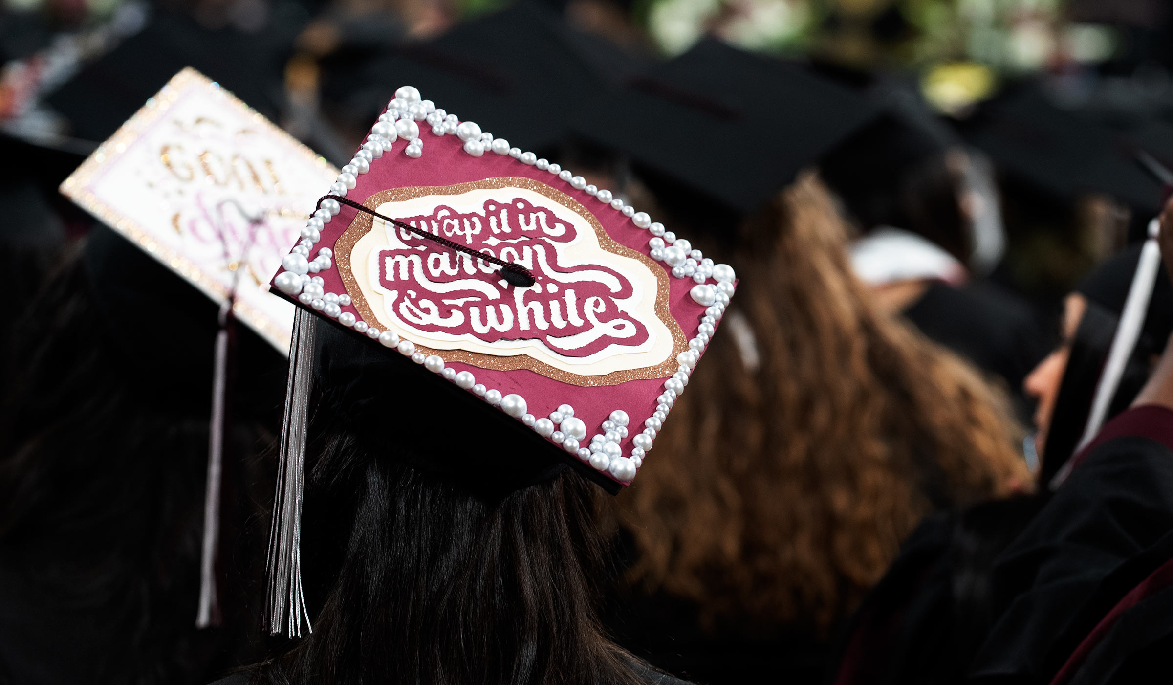 Graduate's mortar board with "Wrap it in Maroon & White" on top