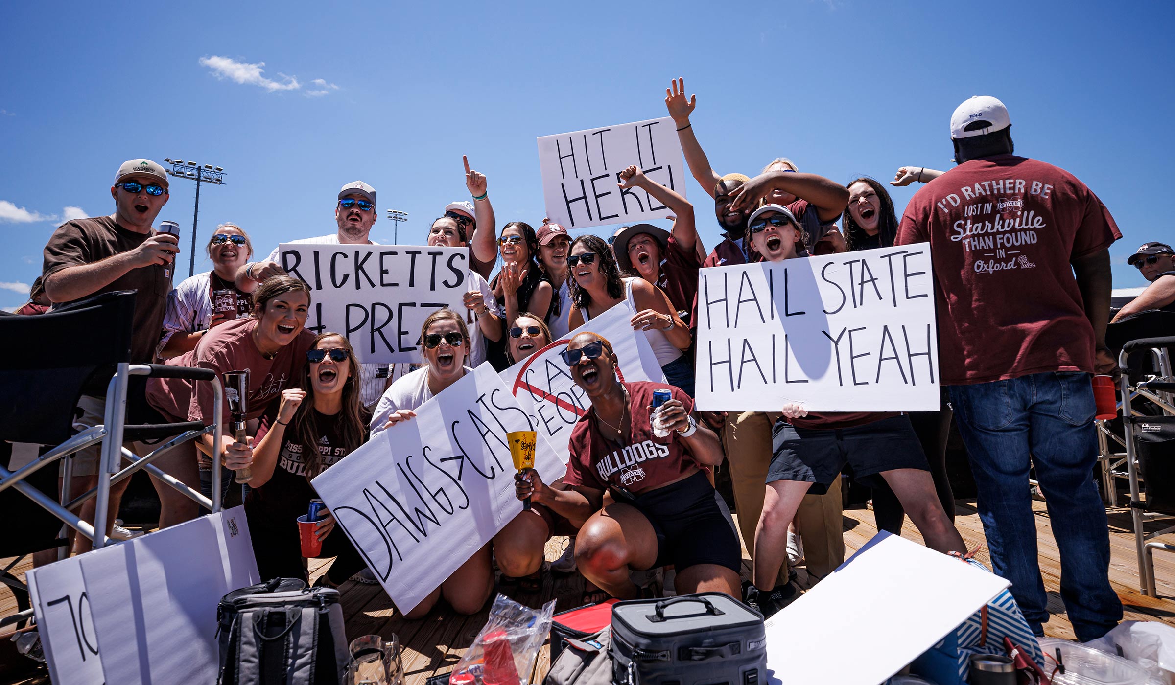 Fans in maroon and white with signs cheering