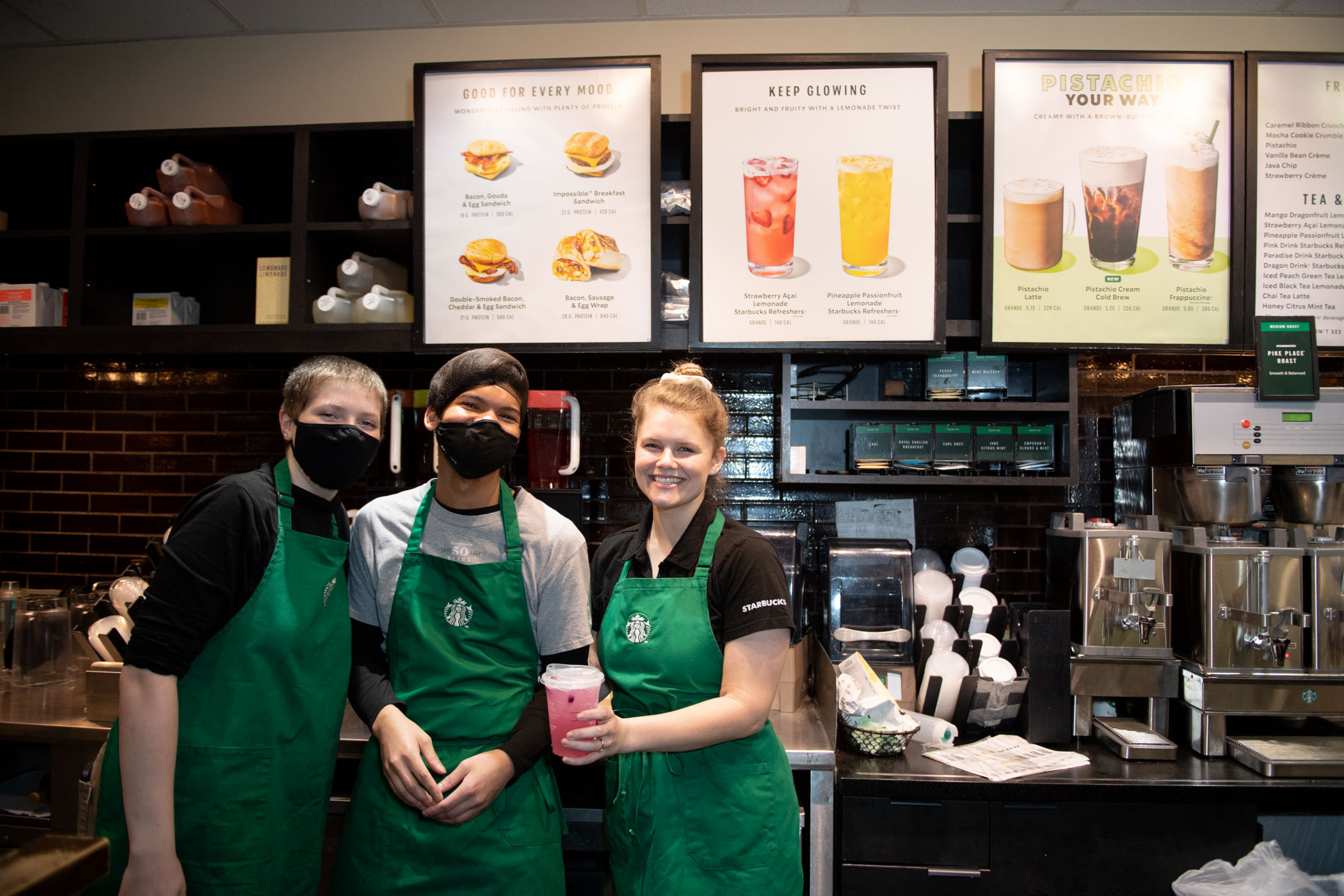 Staff of MSU's Starbucks, located inside Colvard Student Union, smile for the camera while showing off one of many drink options on the menu.
