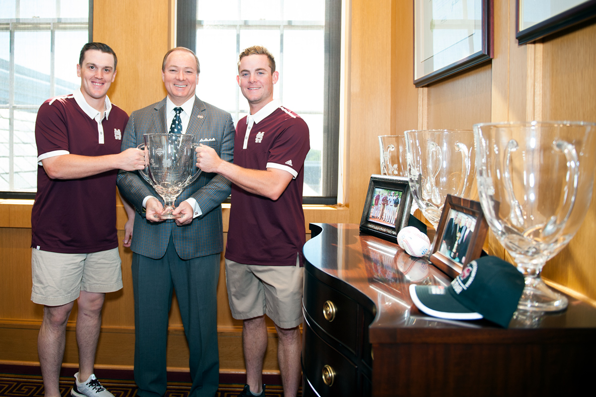 Baseball players present President Keenum with the Governor's Trophy.
