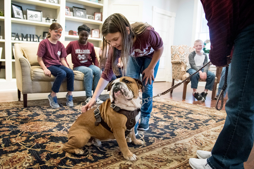 Children at Palmer Home in Columbus take turns petting MSU Bulldog mascot Jak during the College of Veterinary Medicine's Animals in Focus outreach program.