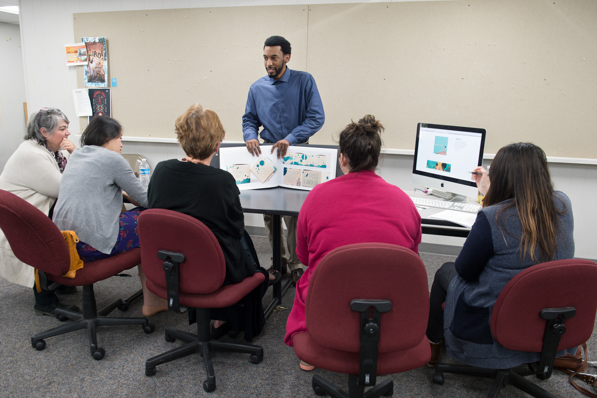 Student Josh Green presents his print and web portfolios to Graphic Design faculty at the end of the semester.