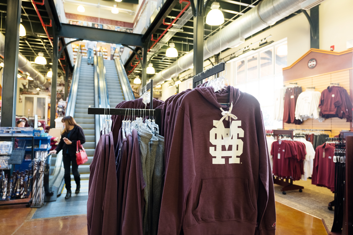 With MSU merchandise in the foreground, Barnes & Noble holiday shoppers descend the escalators in the background.